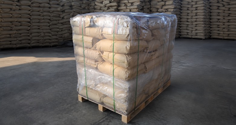 Wrapped pallet of kraft paper bags in a dry warehouse handling area