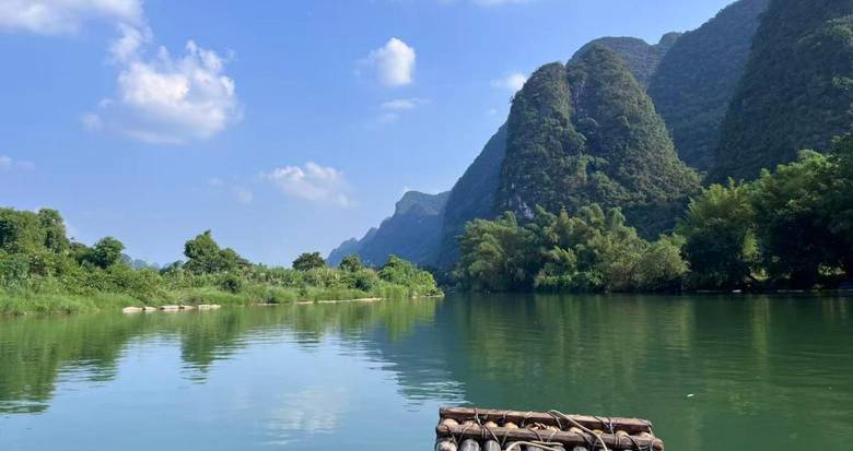 View from a bamboo raft on a calm river in Yangshuo with karst mountains